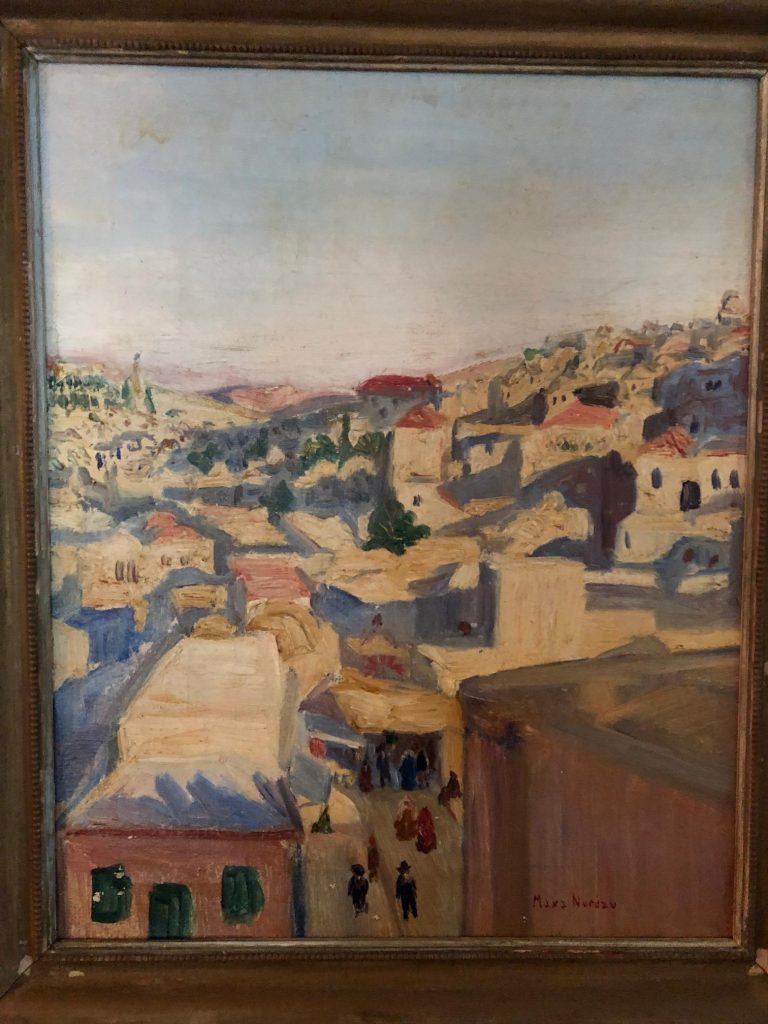 An old frame with a picture painted of a beautiful village scene
